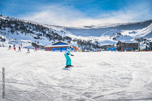 Fotografie Woman, beginner snowboarder learning how to ride on a snowboard