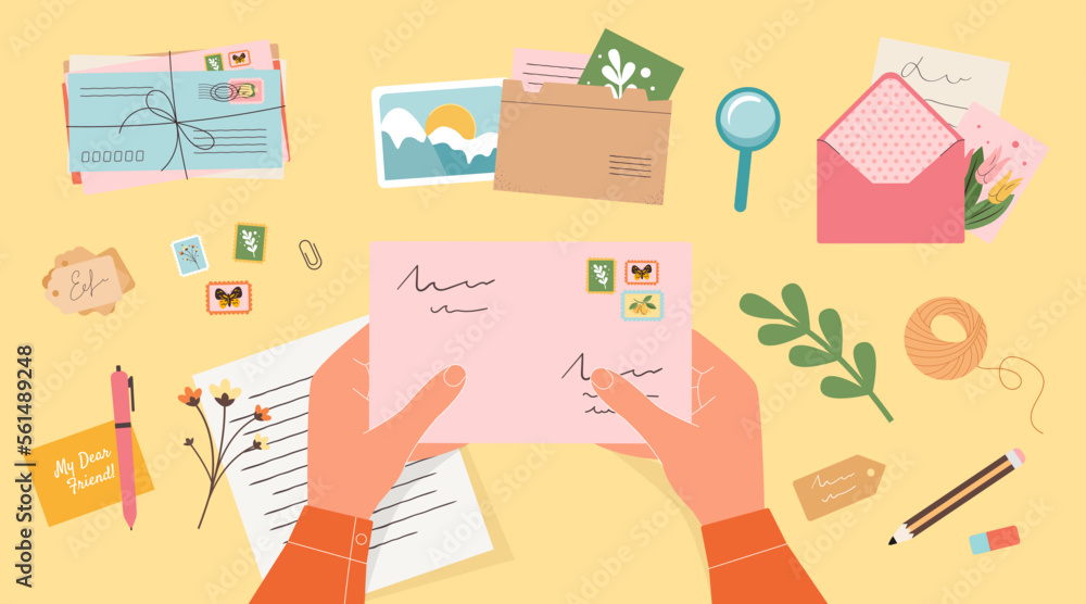 Hands holding closed envelope with stamps. Handwritten letter, postcards, photo card, labels, office supplies top view yellow background. The concept of sending letters and postcards to a friend. Hands holding closed envelope with stamps. Handwritten letter, postcards, photo card, labels, office supplies top view yellow background. The concept of sending letters and postcards to a friend.
