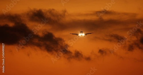Beautiful orange sunset landscape with a flying cargo plane. Transport cargo plane silhouette, dramatic sky. Departure of the aircraft. The takeoff of an aircraft designed to transport various cargoes