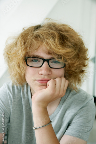 Portrait of teenage boy with big hair and glasses photo