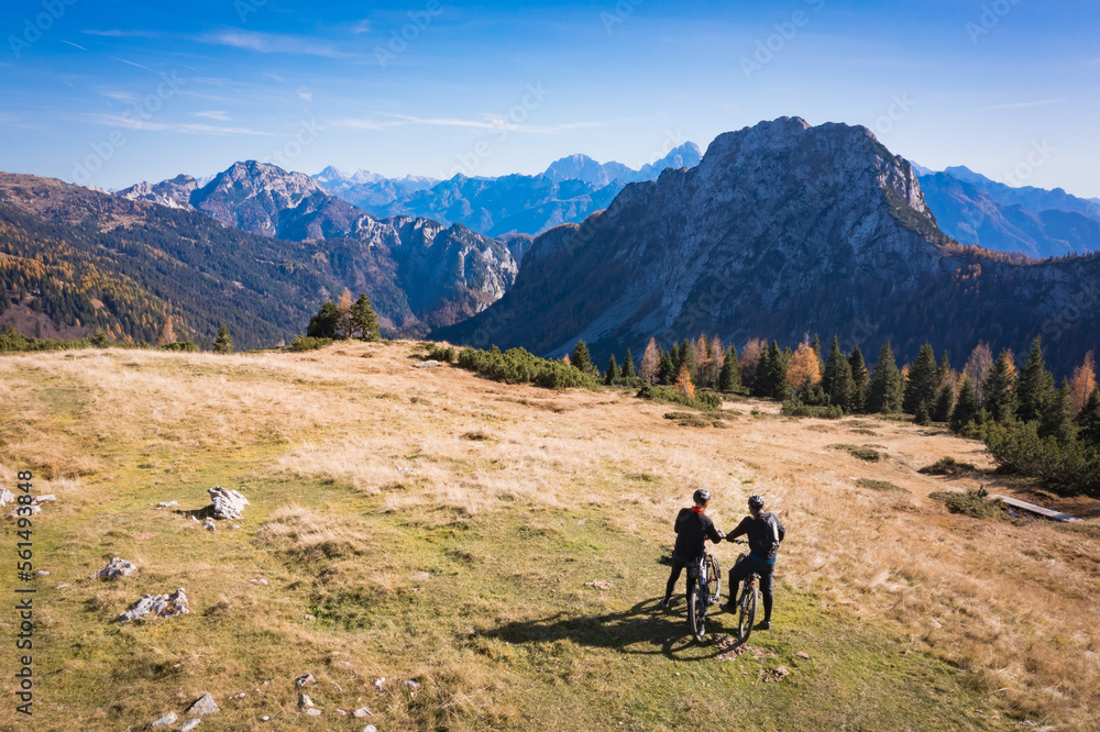 Mountainbiking in the Austrian Alps. Silhuette of a mountainbikers enjoying the scenic views of Nassfeld during late afternoon in autumn.