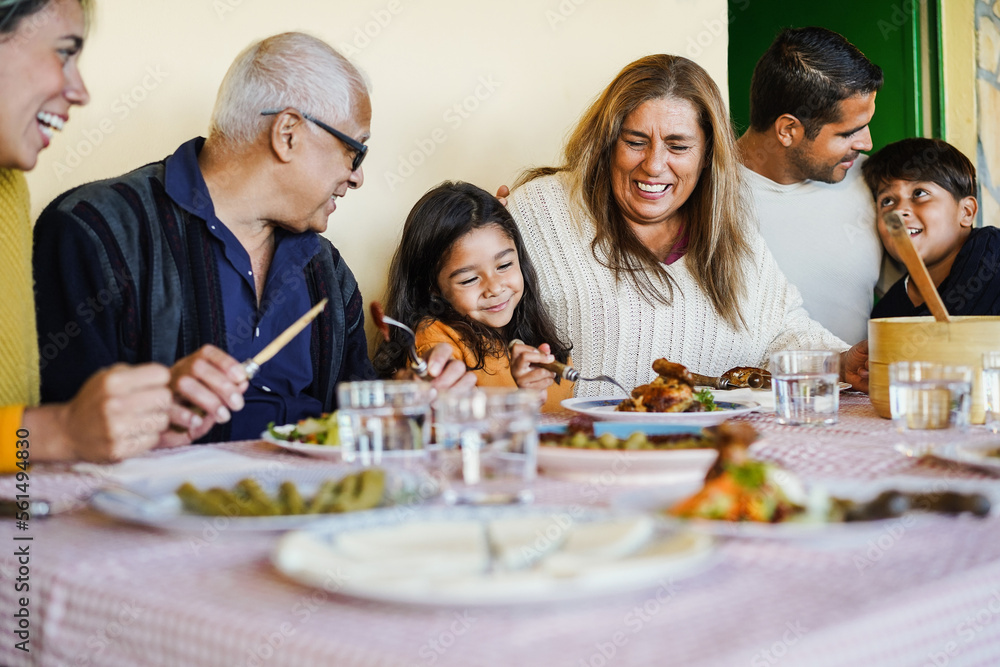 Happy latin family having fun eating together home - Focus on grandmother face Happy latin family having fun eating together home - Focus on grandmother face