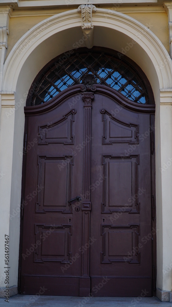 door. Old wooden entrance doors with a brass handle in the city. Arched door. A beautiful street door with an arch