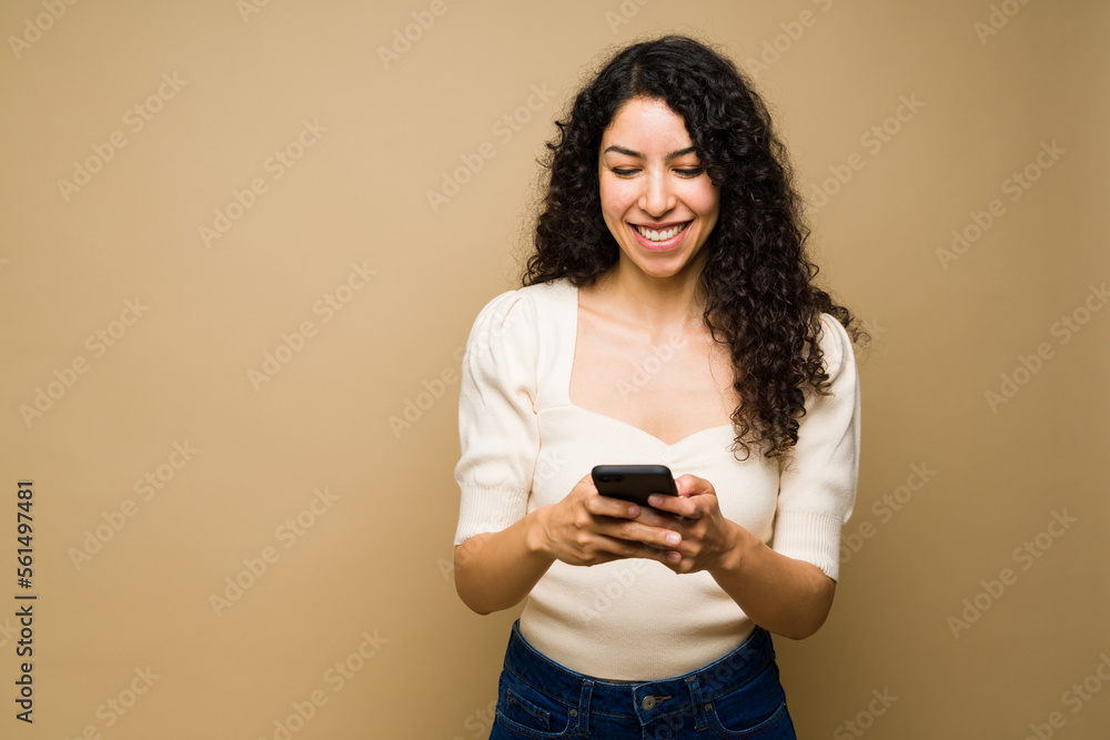 Cheerful woman texting or using social media on her phone Cheerful woman texting or using social media on her phone
