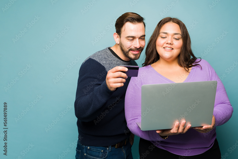 Attractive couple doing online shopping with a credit card Attractive couple doing online shopping with a credit card