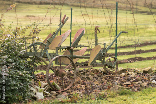 An old ploughing tool. Two-row rotary plough for ploughing. Background of a vineyard.