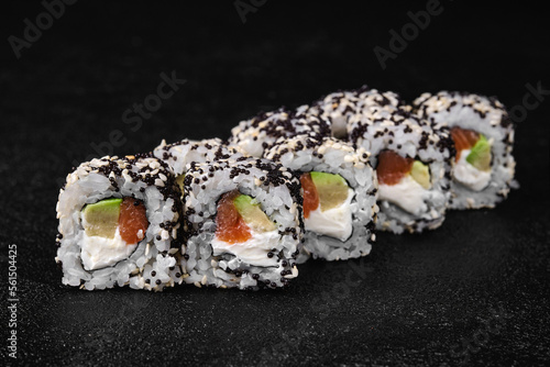 sushi roll with salmon and avocado inside and black flying fish roe on top