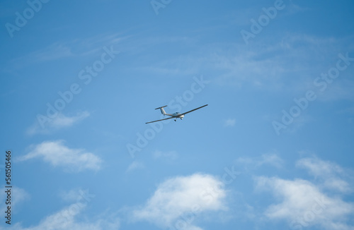 a low wing two-seat self-launching motor glider flying in a blue sky