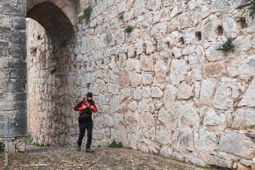 front view of a backpacker walking past a medieval castle