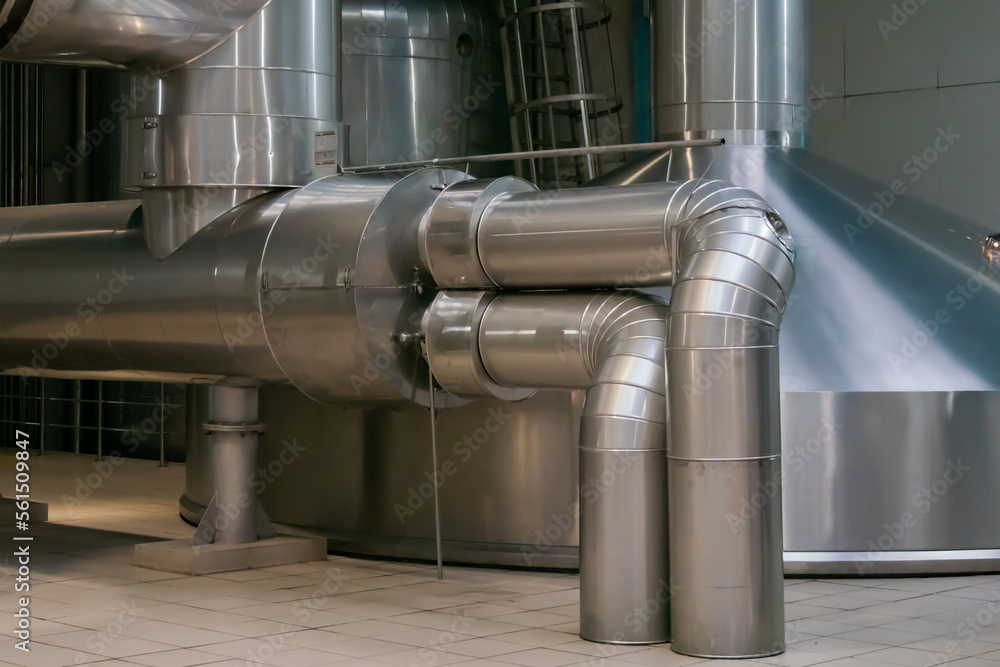 Steel pipes and tank for wort boiling at beer factory - brewery equipment. Production, manufacture, industrial concept Steel pipes and tank for wort boiling at beer factory - brewery equipment. Production, manufacture, industrial concept