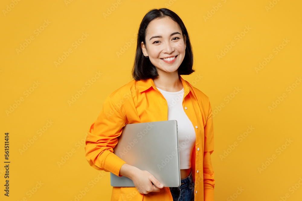 Young IT woman wears summer casual clothes hold closed laptop pc computer isolated on plain yellow background. Tourist travel abroad in free spare time rest getaway. Air flight trip journey concept. Young IT woman wears summer casual clothes hold closed laptop pc computer isolated on plain yellow background. Tourist travel abroad in free spare time rest getaway. Air flight trip journey concept.