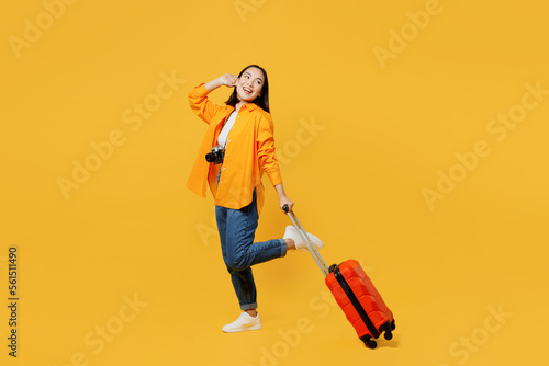 Young woman in summer casual clothes stand with suitcase bag hold face look aside isolated on plain yellow background. Tourist travel abroad in free time rest getaway Air flight trip journey concept #561511490
