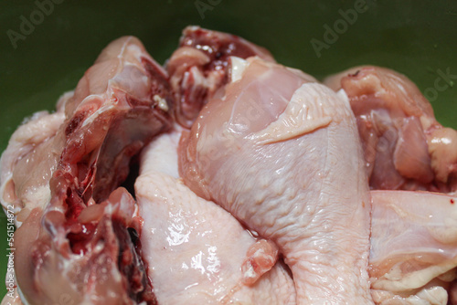 Raw chicken meat cuts inside green bowl, uncooked, selective focus photo