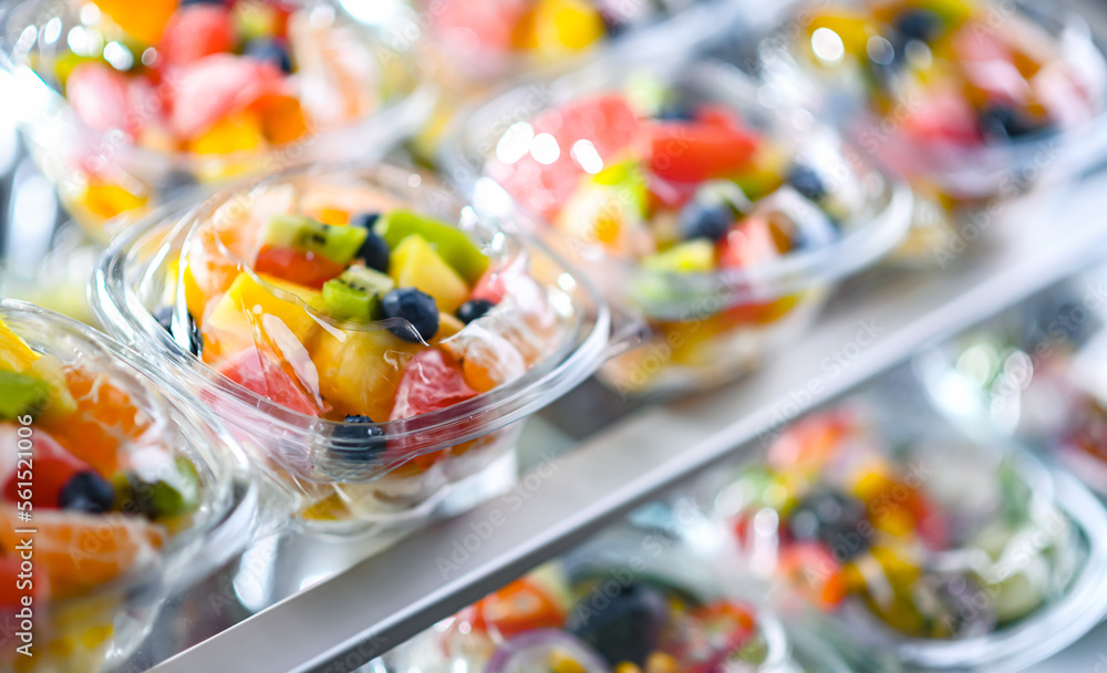 Boxes with pre-packaged fruit salads in a commercial fridge