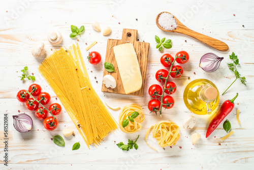 Italian food background on white kitchen table. Ingredients for cooking pasta. Top view with copy space.