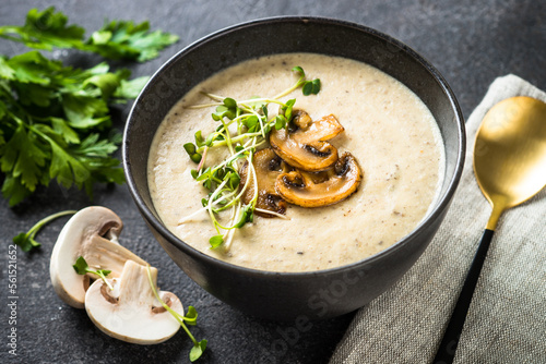 Mushroom Soup on dark stone table. Healthy vegan dish. Autumn soup. photo