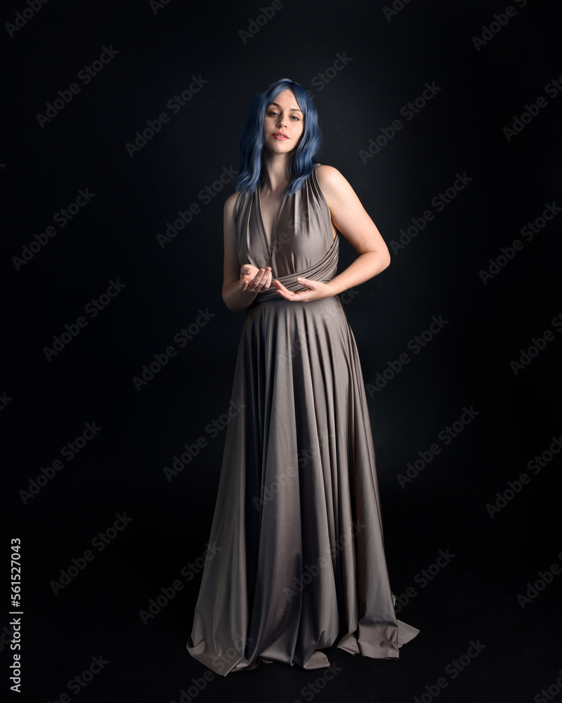 close up portrait of pretty girl with blue hair wig & elegant gown with expressive facial expressions & gestural arm poses. colourful neon gel lighting, isolated on studio background. close up portrait of pretty girl with blue hair wig & elegant gown with expressive facial expressions & gestural arm poses. colourful neon gel lighting, isolated on studio background.