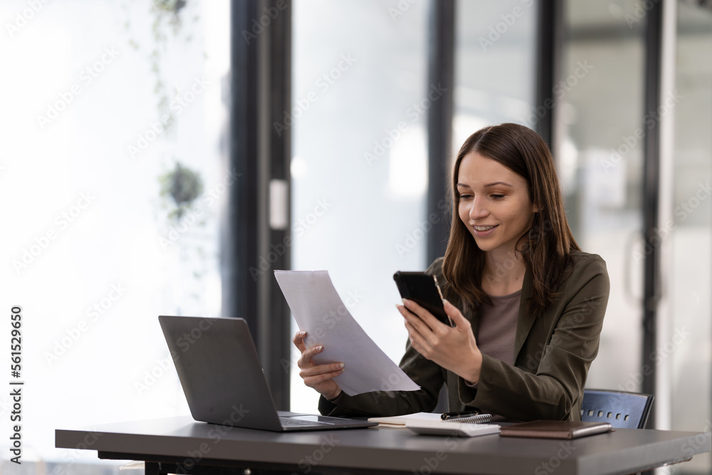 Business woman using smartphone for do math finance on wooden desk in office, tax, accounting, financial concept. Business woman using smartphone for do math finance on wooden desk in office, tax, accounting, financial concept.