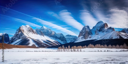 A snow covered plain with snowy mountains in the background. 