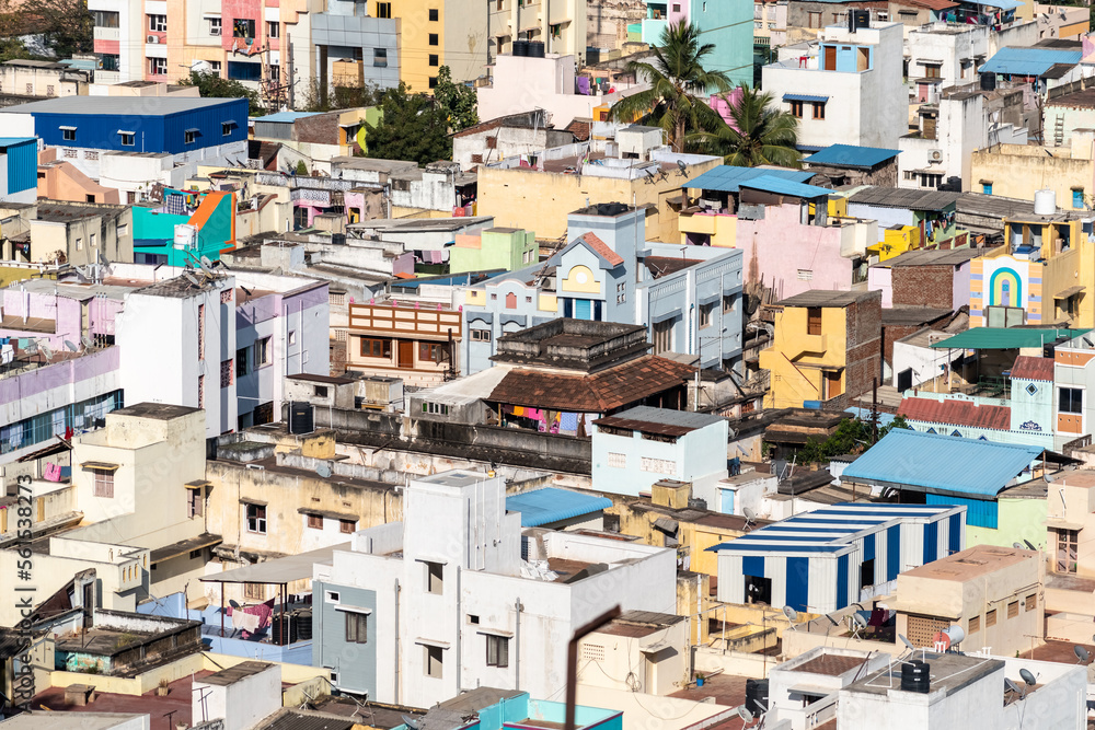 An aerial view of a cluster of concrete low rise houses and buildings in a congested neighborhood in the town of Tiruchirappalli.