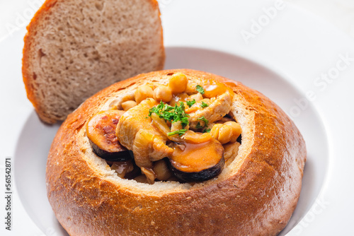 stew with pork meat, chickpeas and sausge in loaf of bread