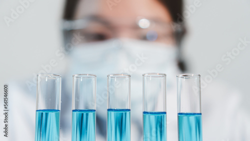 Asian woman Scientist experimental in laboratory with test tube and beaker for medical research