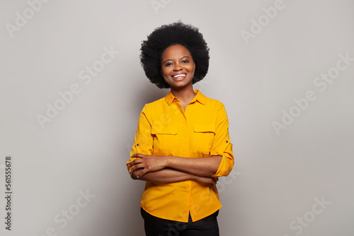 Business woman smiling at camera with crossing hands on white studio background
