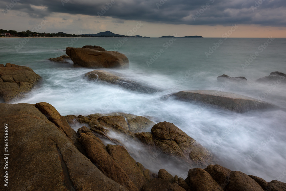 Artistic seascape with blurry waves crashing against granite rocks on the shore, Samui, Thailand