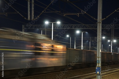 Pociąg towarowy w czasie jazdy po torach kolejowych nocną porą © Sławek