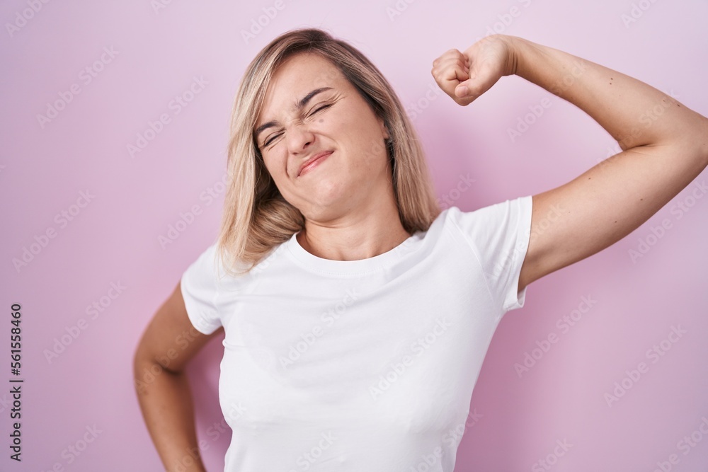 Young blonde woman standing over pink background stretching back, tired and relaxed, sleepy and yawning for early morning Young blonde woman standing over pink background stretching back, tired and relaxed, sleepy and yawning for early morning