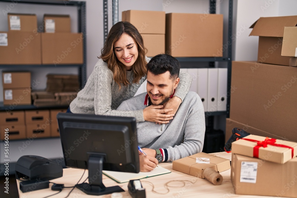 Man and woman ecommerce business workers hugging each other working at office Man and woman ecommerce business workers hugging each other working at office