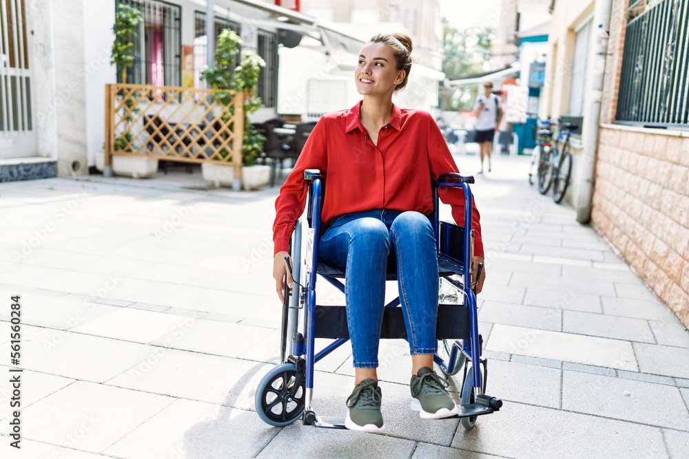 Obraz premium Young woman smiling confident sitting on wheelchair at street