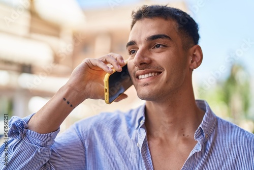 Young hispanic man smiling confident talking on the smartphone at street