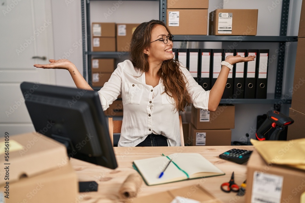 Young hispanic woman working at small business ecommerce smiling showing both hands open palms, presenting and advertising comparison and balance Young hispanic woman working at small business ecommerce smiling showing both hands open palms, presenting and advertising comparison and balance