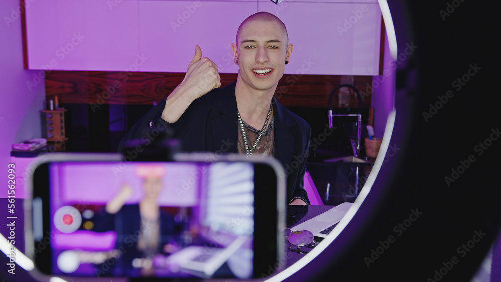 Young male blogger recording himself with smartphone indoor. High quality photo Young male blogger recording himself with smartphone indoor. High quality photo