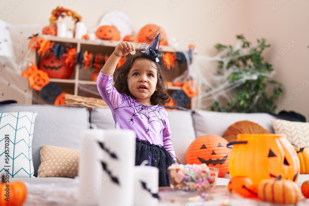Fototapeta premium Adorable hispanic toddler having halloween party standing at home