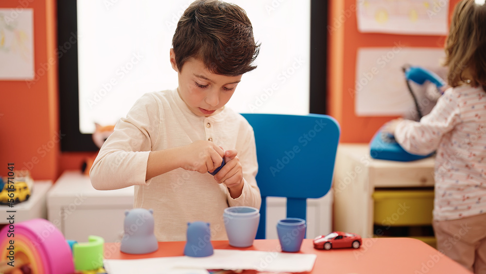 Adorable hispanic boy playing with toys standing at kindergarten Adorable hispanic boy playing with toys standing at kindergarten