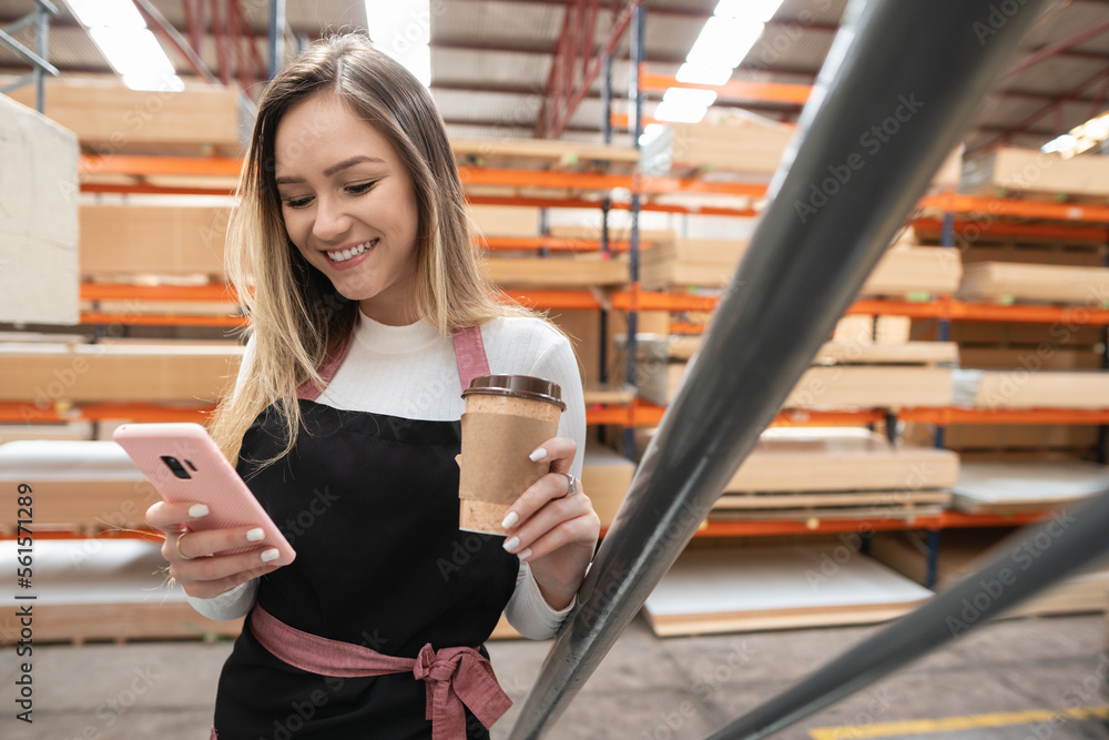 Fototapeta premium happy businesswoman checking mobile phone to work and view request at warehouse