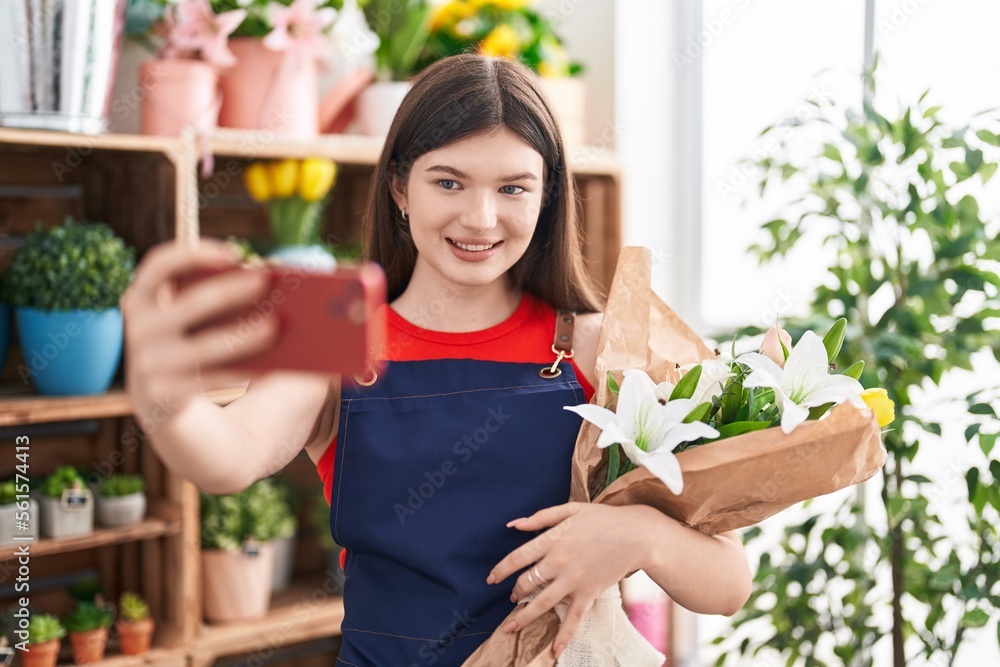 Young caucasian woman florist make selfie by smartphone holding flowers at florist Young caucasian woman florist make selfie by smartphone holding flowers at florist