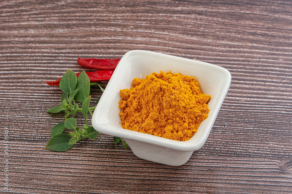 Yellow vibrant curcuma powder in the bowl