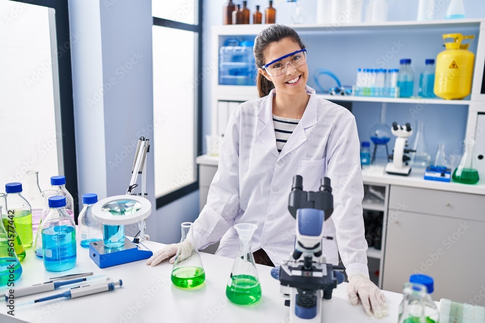 Young beautiful hispanic woman scientist smiling confident standing at laboratory Young beautiful hispanic woman scientist smiling confident standing at laboratory