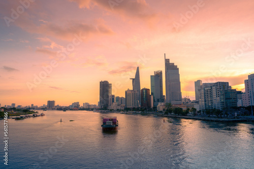 Aerial sunset view of Bitexco Tower  buildings  roads  Bason bridge and Saigon river in Ho Chi Minh city  container cargo ship on Saigon river. Travel concept.