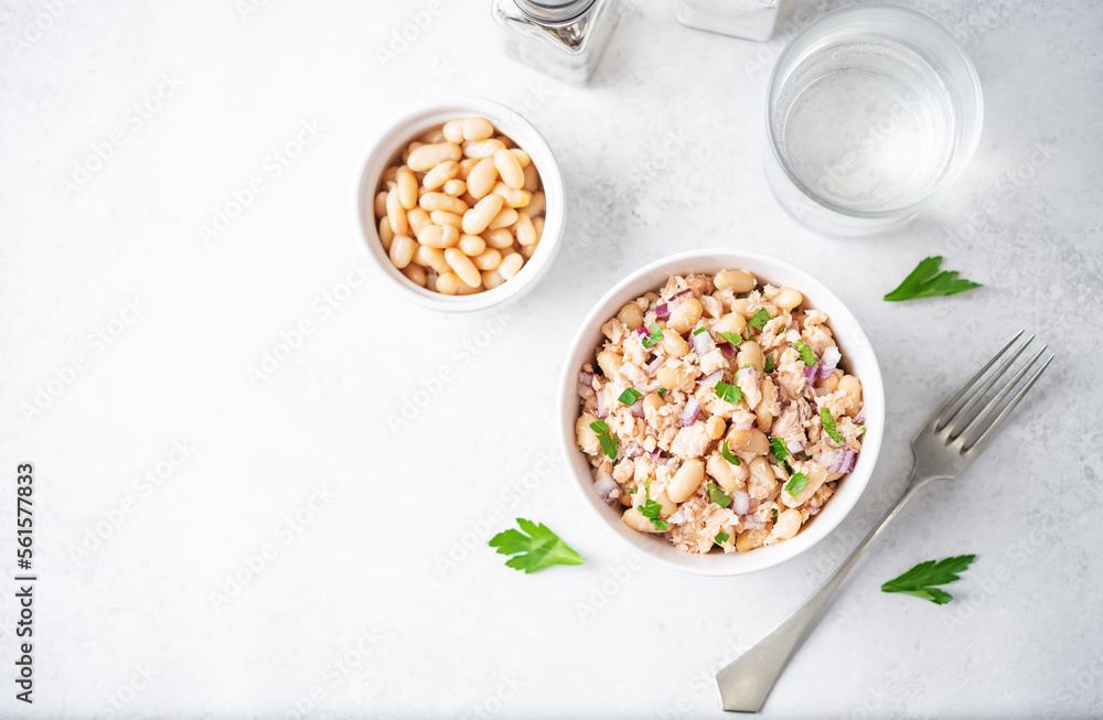 Cooked salmon white bean red onion salad in a bowl Cooked salmon white bean red onion salad in a bowl