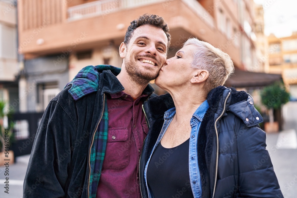 Mother and son smiling confident standing together kissing at street