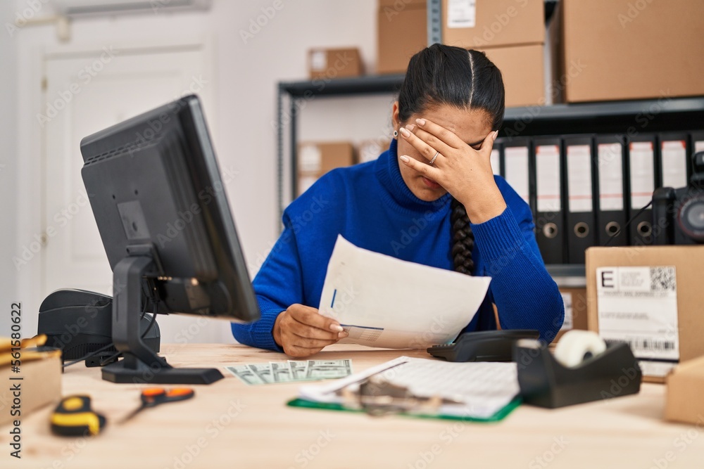 Young hispanic woman ecommerce business worker reading document at office Young hispanic woman ecommerce business worker reading document at office
