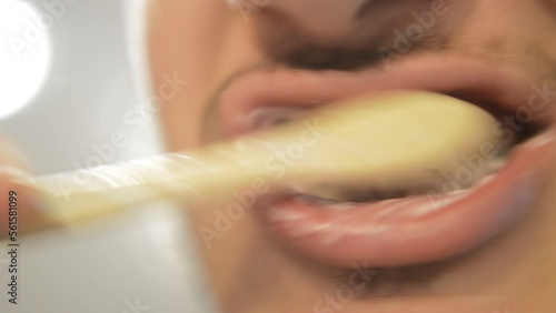 close-up man brush teeth in a blur bathroom background.