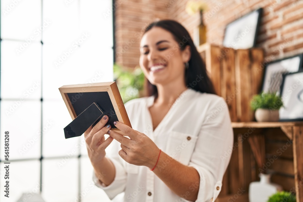 Young beautiful hispanic woman smiling confident looking photo at home Young beautiful hispanic woman smiling confident looking photo at home