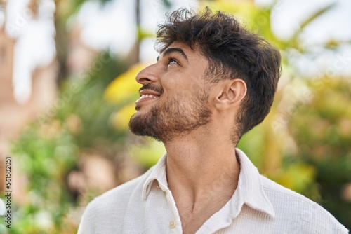 Young arab man smiling confident looking to the side at park