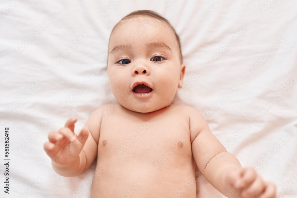 Adorable hispanic toddler smiling confident lying on bed at bedroom Adorable hispanic toddler smiling confident lying on bed at bedroom