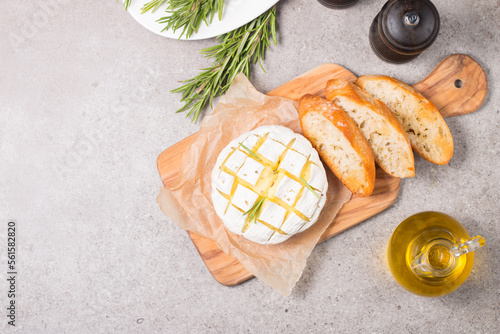 Baked camembert soft cheese. Grilled brie with toasts and rosemary. 